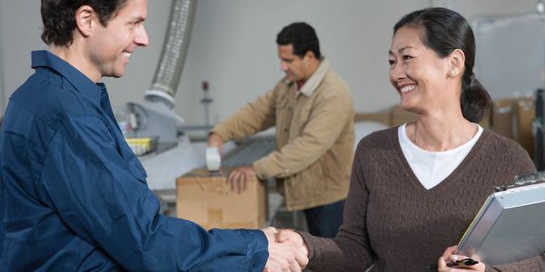Two people shaking hands at a workplace.