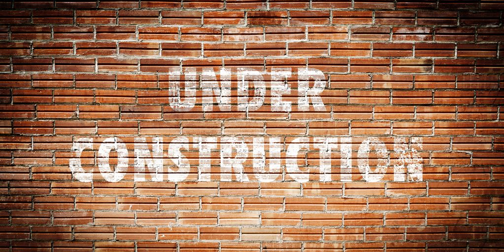 'Under Construction' sign on a brick wall.