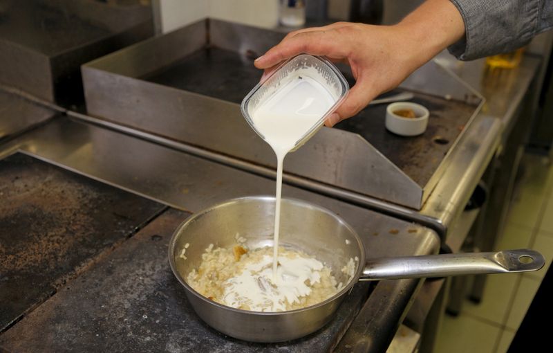 Chef is cooking risotto at professional kitchen