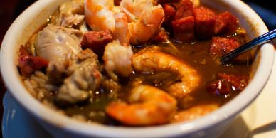 A bowl of seafood gumbo with shrimp and sausage.