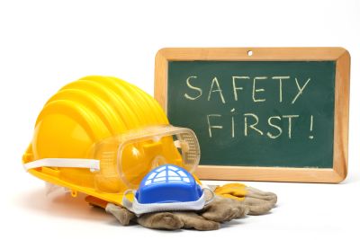 Safety gear with 'Safety First!' on chalkboard.