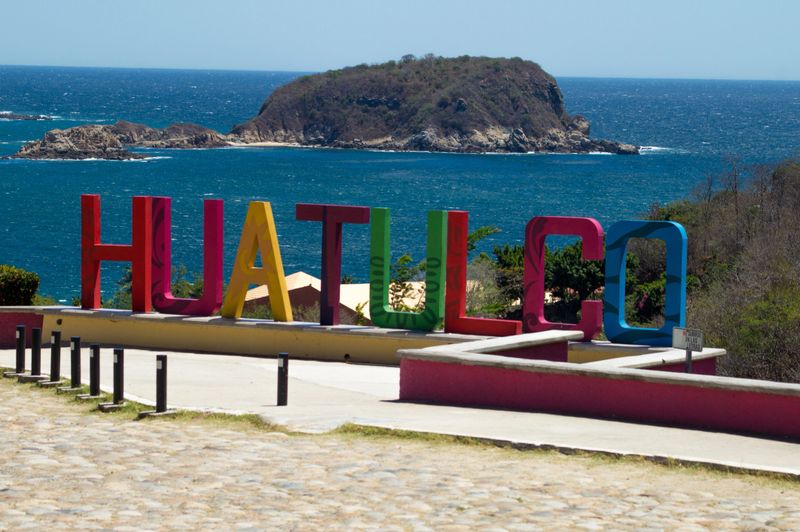 View of Tangolunda bay at Huatulco Oaxaca Mexico. La Montosa Island in the background and the word HUATULCO in concrete made letters.View of Tangolunda bay at Huatulco Oaxaca Mexico. La Montosa Island in the background and the letter O made of concrete in the main plain.