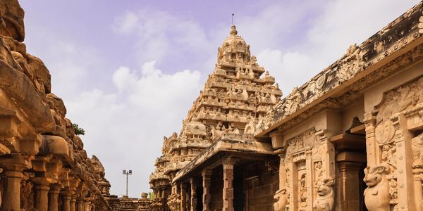Ancient temple with intricate carvings under a partly cloudy sky.