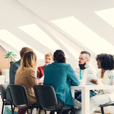 A diverse group of professionals having a meeting around a table in a modern office.