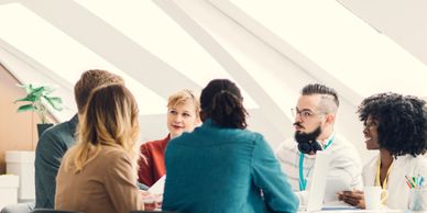 A diverse group of young professionals in a bright office having a meeting.