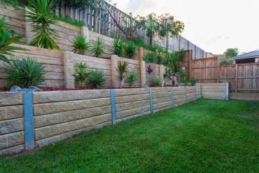 Tiered garden with retaining walls and green plants.