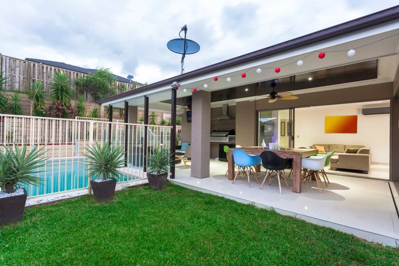 Outdoor entertaining area and pool in stylish home at dusk