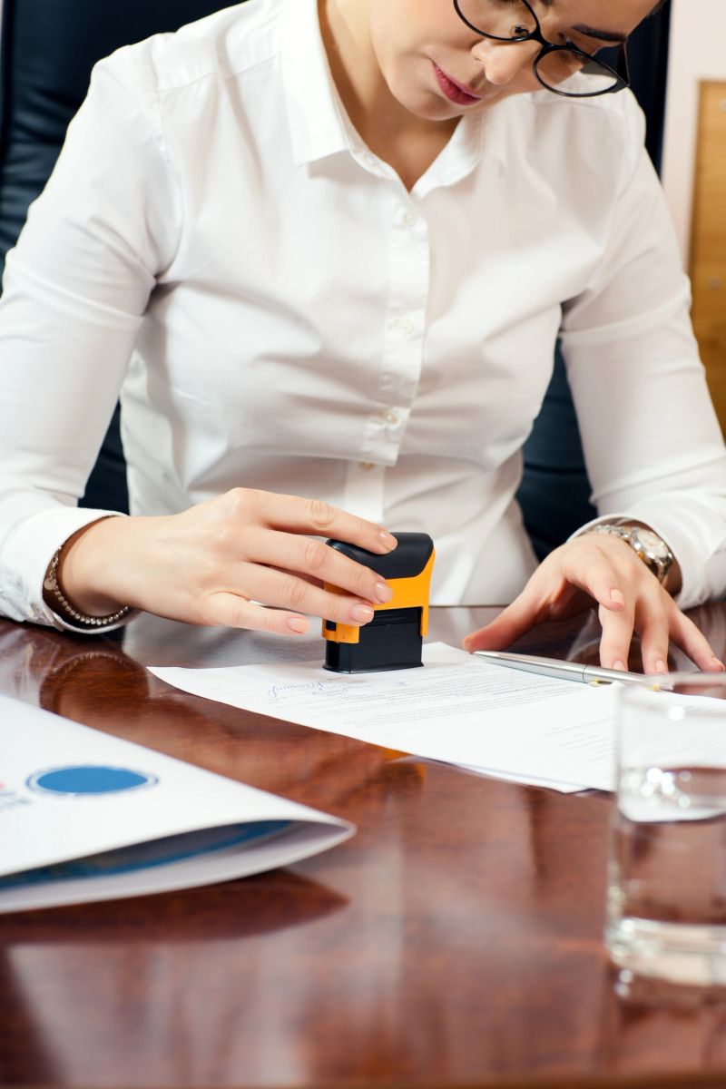 businesswoman stamping document, working at her office