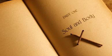 Open book titled 'Soul and Body' with incense sticks forming a cross.