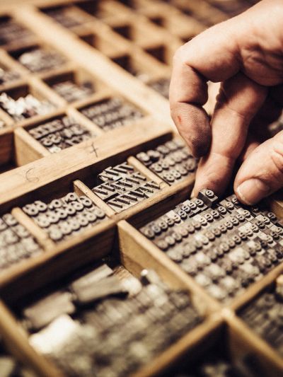 Hand selecting metal type for printing.