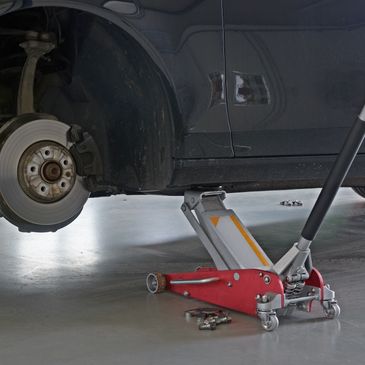 Car lifted with a jack for tire repair.