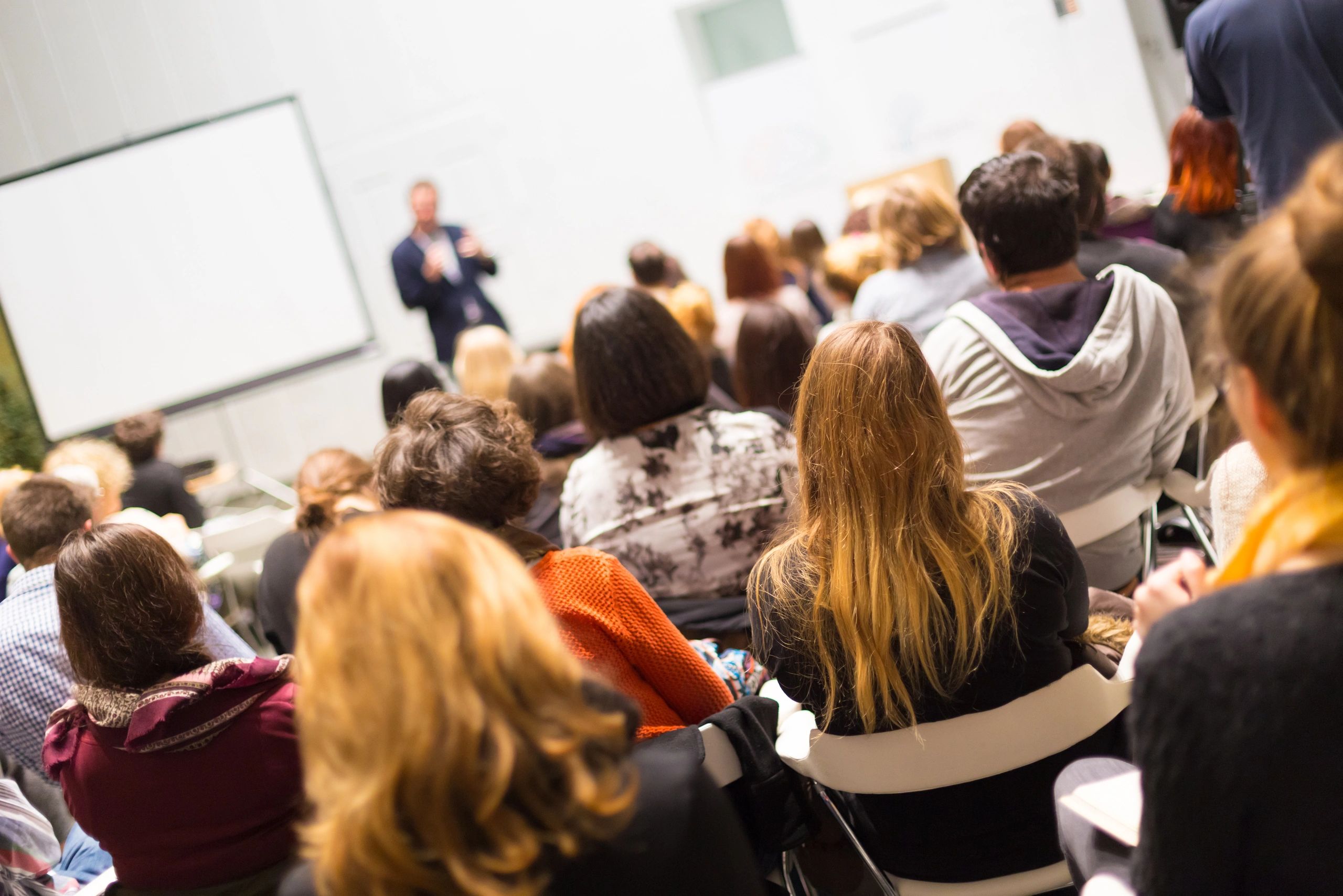 Audience attentively listening to a speaker in a seminar.