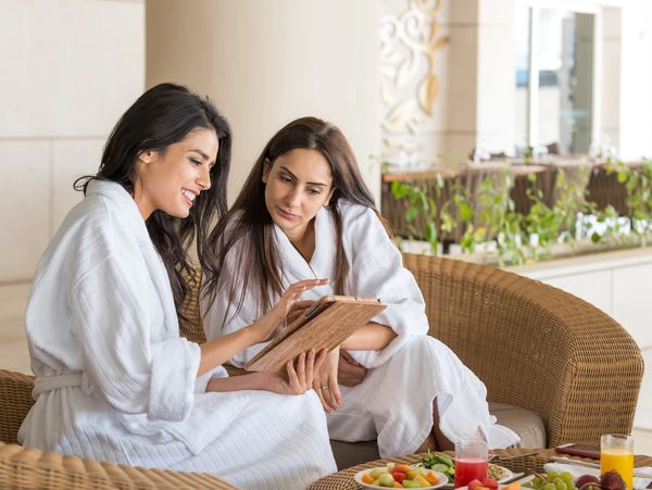 2 women sitting together and looking at a Tablet screen