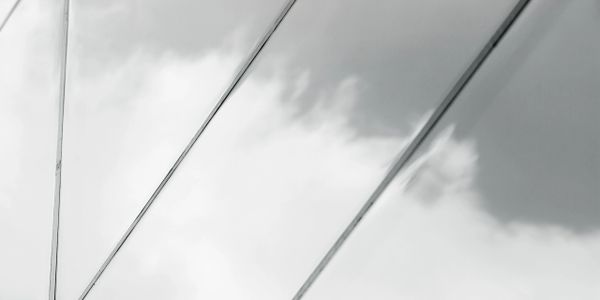 Reflection of cloudy sky on glass building panels.