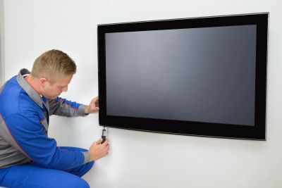 Technician installing a flat-screen TV on a wall.