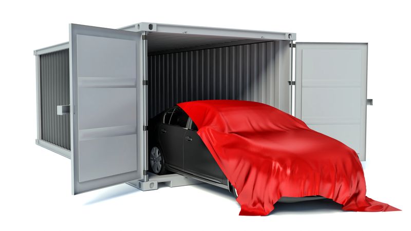 Car covered with red cloth and container