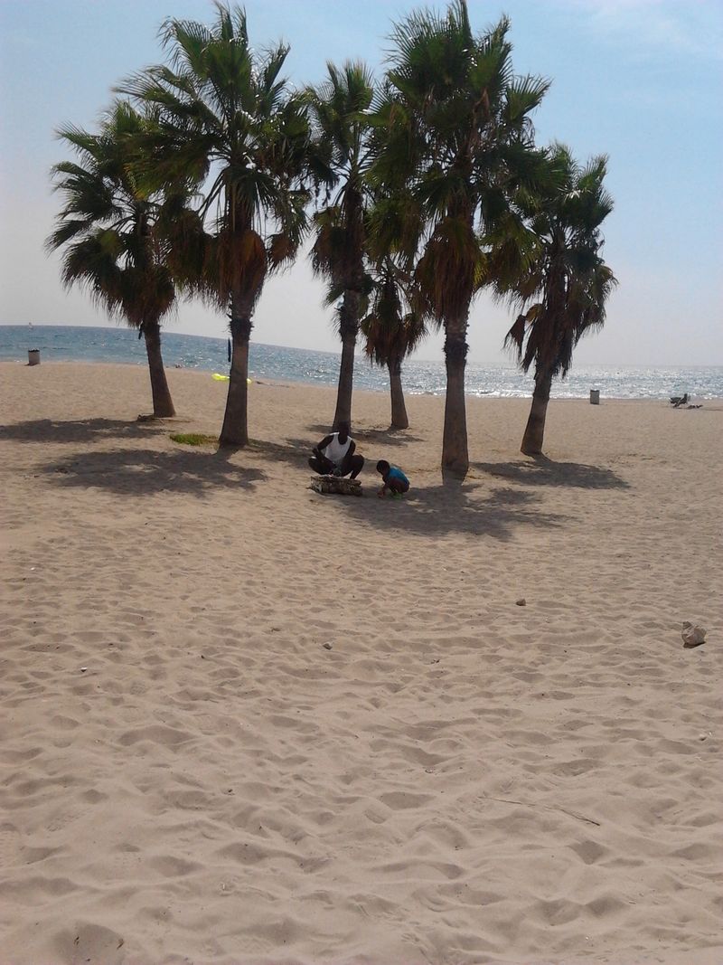 Father and son playing in Calafell beach , Spain.