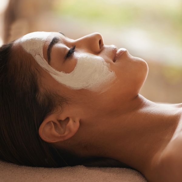 Woman relaxing with a facial mask applied on her face.