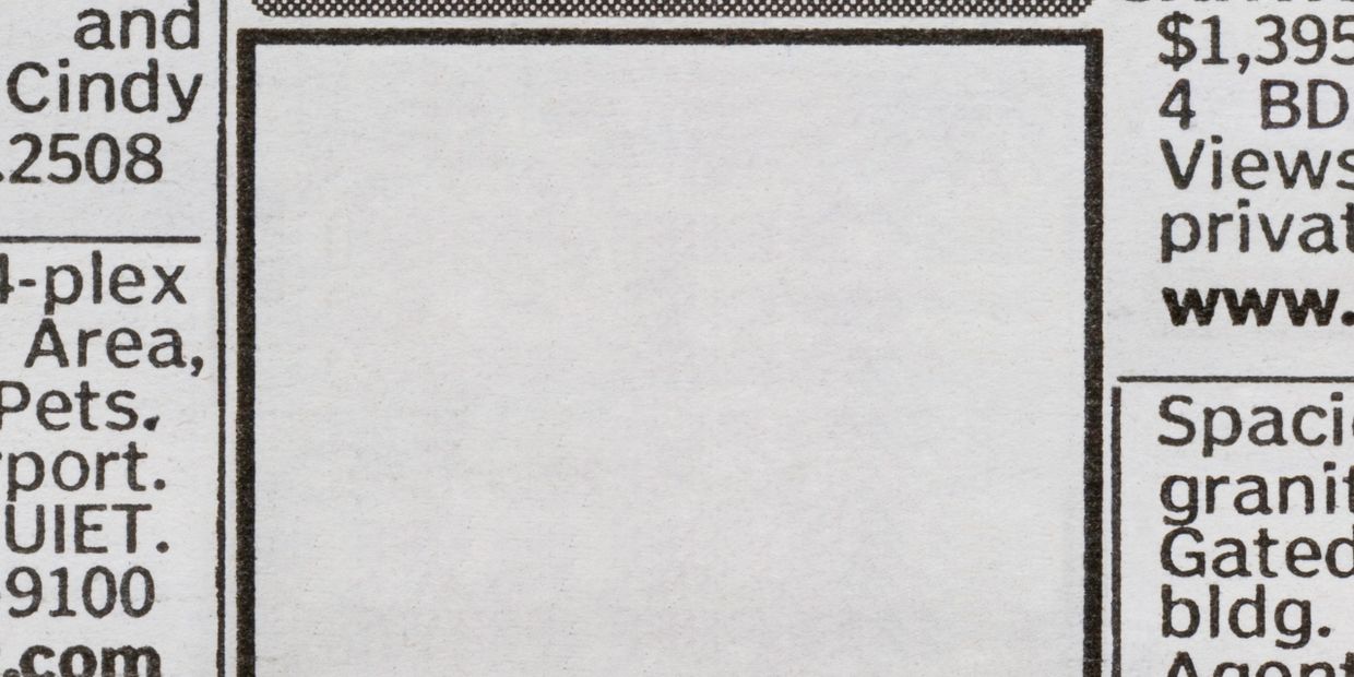 Close-up of newspaper text columns with partial words and numbers.