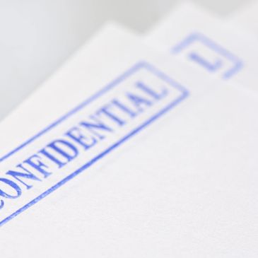Stack of confidential documents with blue stamps.