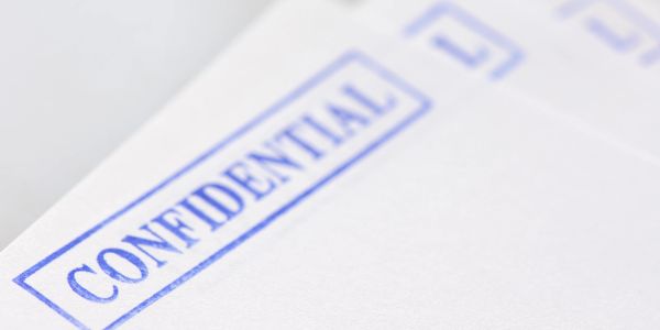 Stack of confidential documents with blue stamps.