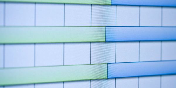 Close-up of a digital bar chart with green and blue bars on a grid background.