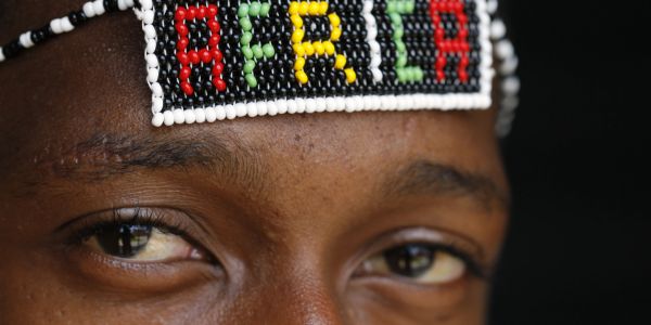 Close-up of eyes with a beaded headband spelling 'AFRICA'.