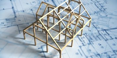 Wooden model structure on architectural blueprints.