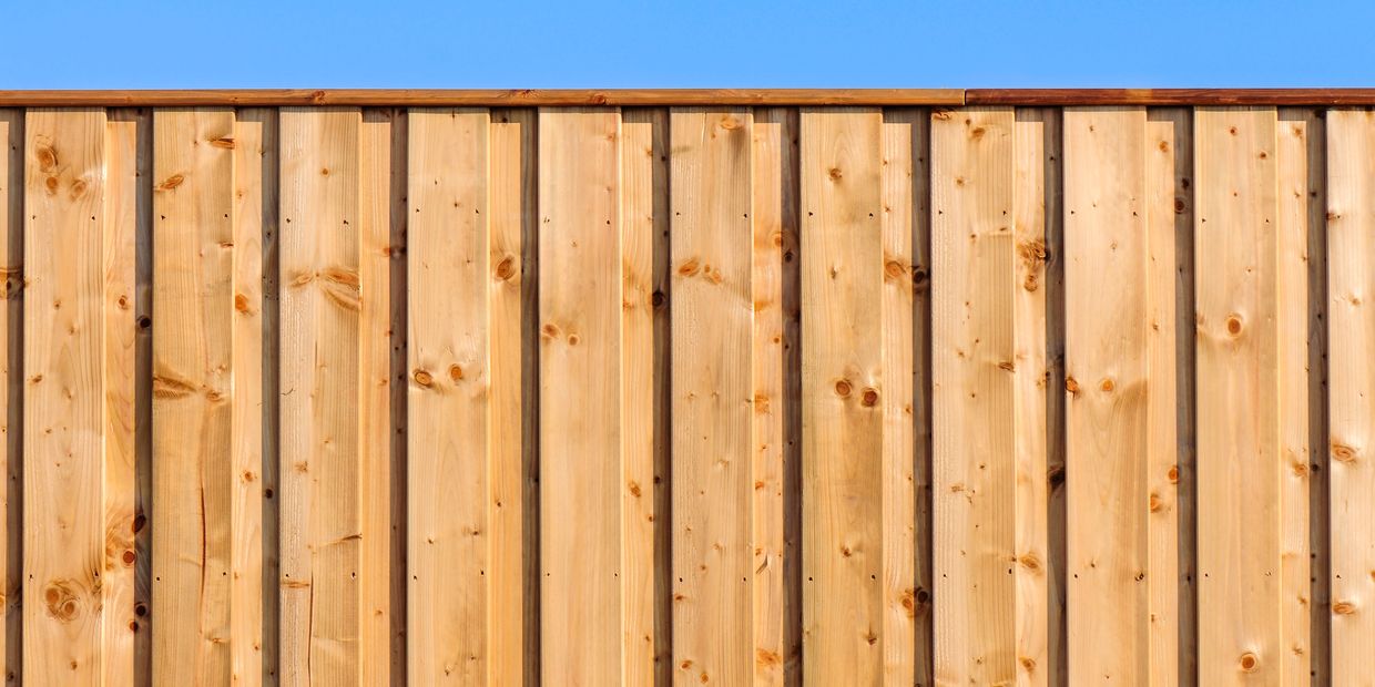 Wooden fence under a clear blue sky.