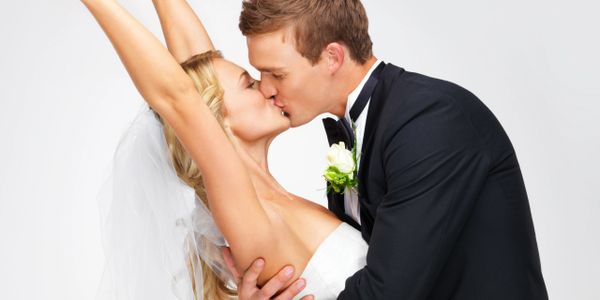 Bride and groom sharing a romantic kiss on their wedding day.
