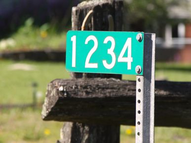Green house number sign with digits 1234.