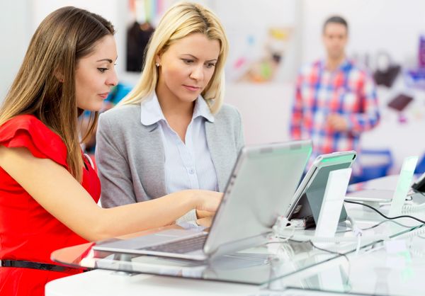 Ladies shopping for refurbished computer deals.