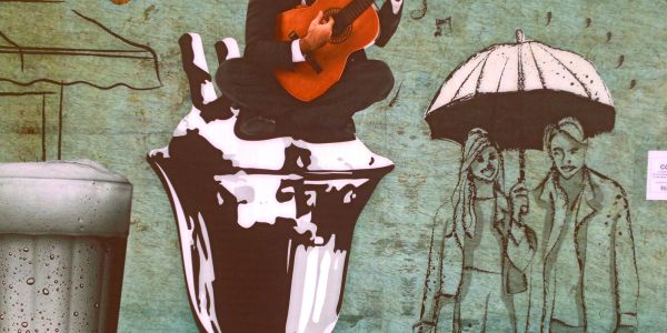Grafiti artístico con una persona tocando guitarra.