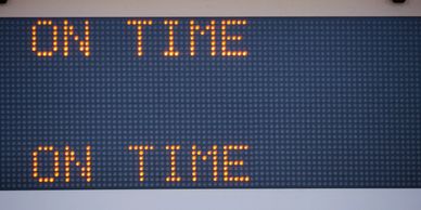 Digital sign displaying 'ON TIME' twice in orange text.
