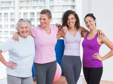 four women talking with their arms around each other