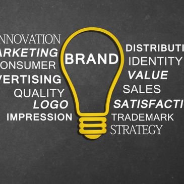 A yellow lightbulb with the word BRAND surrounded by marketing-related terms on a dark background.