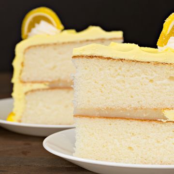 Two slices of lemon cake with yellow frosting and lemon candy.
