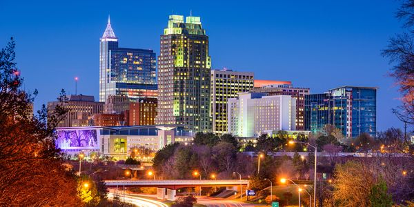 City skyline at dusk with illuminated buildings.