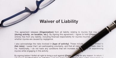 A waiver of liability document with a pen and glasses on top.