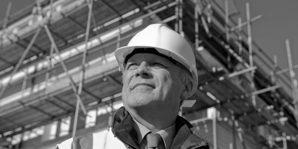 Confident construction worker in hard hat at work site.