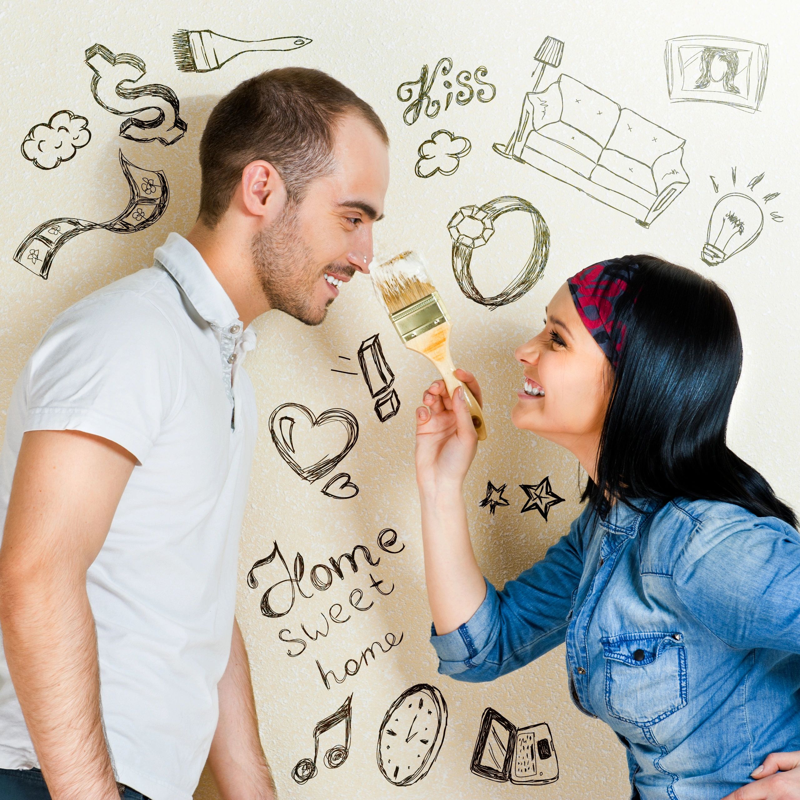 Couple playfully painting a wall with home-themed doodles and smiling at each other.
