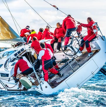 Team in red jackets sailing a boat.
