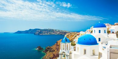 White buildings with blue domes overlooking the sea in Santorini, Greece.
