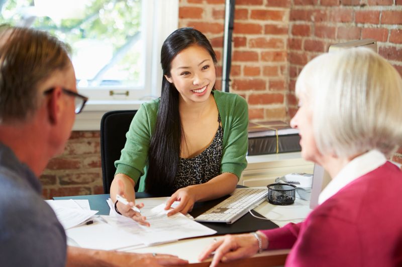 Senior Couple Meeting With Happy Smiling Asian Financial Advisor In Office