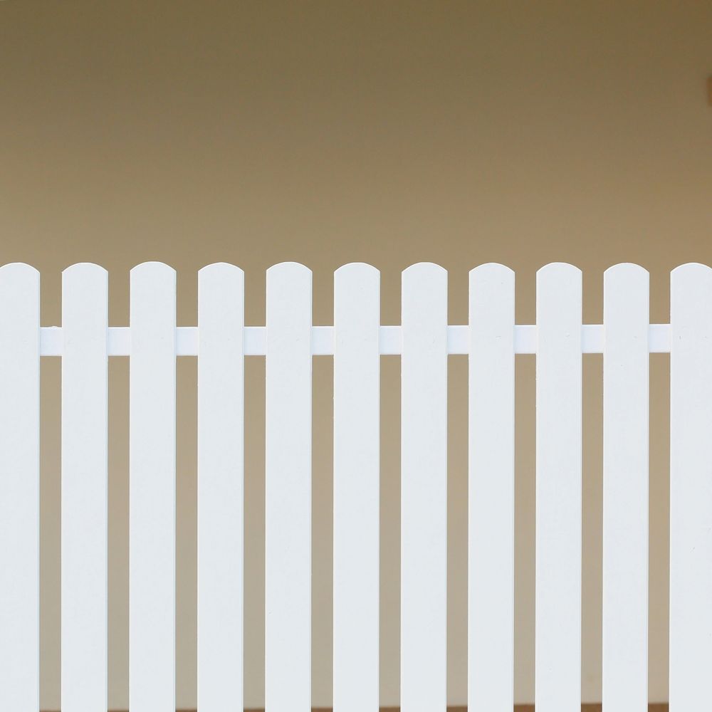 White picket fence with beige background.