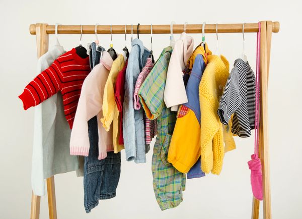 Clothing neatly hanging on a clothing rack.