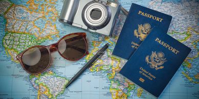 Travel essentials: passports, camera, sunglasses on a map.