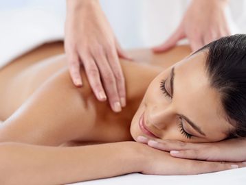 Woman getting a therapeutic massage for her tight muscles to relieve neck and back pain.