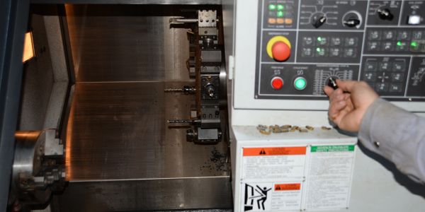 Birisi CNC makinesini kumanda ediyor.