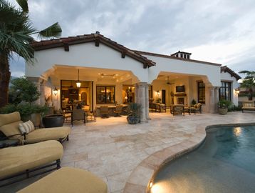 Elegant backyard patio with pool and comfortable seating under a covered veranda.